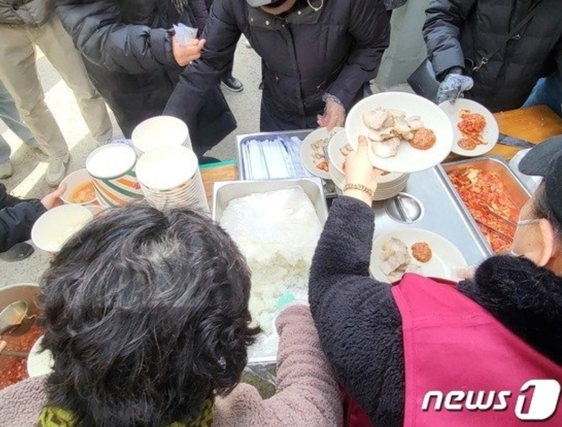 2日、大邱のモスク工事現場前で建設に反対する住民らが豚のゆで肉などを食べている(c)news1