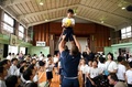 熊本市内の小学校を訪れ、ラインアウトの動きで児童を担ぎ上げるフランスのヤクーバ・カマラ（中央奥）とグレゴリー・アルドリット（中央手前、2019年9月26日撮影）。(c)FRANCK FIFE / AFP