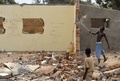 中央アフリカの首都バンギ（Bangui）で、なたを使ってモスクの壁を壊す若い男性（2014年1月11日撮影）。(c)AFP/ERIC FEFERBERG