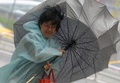 台風による強い雨と風に見舞われた台湾・新北市で傘を持つ女性（2015年9月28日撮影、資料写真）。(c)AFP/SAM YEH