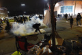 米ミズーリ（Missouri）州ファーガソン（Ferguson）で、警察が使用した催涙ガスから逃げる、黒人青年の射殺事件に抗議するデモに参加する人々（2014年11月24日撮影）。(c)AFP/Jewel Samad