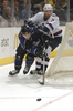写真は、体勢を崩されながらもパックをコントロールするキングスのダスティン・ブラウン（%%Dustin Brown%%、前）。(c)AFP/Getty Images Andrew D. Bernstein