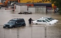 セルビア・ベオグラード（Belgrade）郊外で、水に漬かった車を移動させようとする男性（2014年5月15日撮影）。(c)AFP/ANDREJ ISAKOVIC