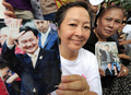 2008年2月28日、タイのバンコク（Bangkok）でタクシン・シナワット（Thaksin Shinawatra）元首相の写真を手に元首相のホテル到着を待つ支持者たち。(c)AFP/Pornchai KITTIWONGSAKUL