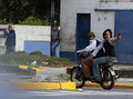 2007年11月7日、ベネズエラの首都カラカス（Caracas）で、大学のキャンパスにバイクで乗りつけ、大統領権限強化を認める改憲案反対デモに参加した学生たちに発砲する2人組。(c)AFP/Pedro REY