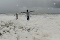 インド南東部チェンナイのマリーナビーチに広がった泡の中で遊ぶ人々（2019年12月1日撮影）。(c)Arun SANKAR / AFP