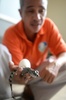 フィリピン・パラワン（Palawan）島のプエルトプリンセサ（Puerto Princesa）にあるパラワン島野生生物保護センター（Palawan Wildlife Rescue and Conservation Centre）で、人工ふ化により誕生したばかりの淡水ワニを手に取る職員（2014年6月6日撮影）。(c)AFP/TED ALJIBE