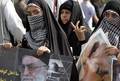 イランの首都テヘラン（Tehran）で、反イスラエルの日に、最高指導者アリ・ハメネイ（Ali Khamenei）師やエルサレム（Jerusalem）にある岩のドーム（Dome of the Rock）の写真を掲げて行進する女性（2009年9月18日撮影）。(c)AFP/ATTA KENARE