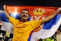 2010年サッカーW杯南アフリカ大会（%%2010 World Cup%%）欧州予選・グループ7、セルビア対ルーマニア。試合はセルビアが5-0で勝利し、本大会出場を決めた。写真は国旗を手に歓喜するセルビアのデヤン・スタンコビッチ（%%Dejan Stankovic%%）。（2009年10月10日撮影）(c)AFP/ANDREJ ISAKOVIC