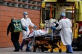 英ロンドンにある病院で、患者を搬送する医療従事者（2021年1月19日撮影）。(c)Tolga Akmen / AFP