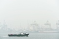 煙害による大気汚染が深刻化しているシンガポールで、厚い煙に覆われた港を通過する船舶（2015年9月24日撮影）。(c)AFP/STEFANUS IAN
