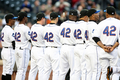 米大リーグ（MLB）で15日、アフリカ系米国人初の大リーガーとして活躍した故ジャッキー・ロビンソン（%%Jackie Robinson%%）氏の栄誉をたたえるジャッキー・ロビンソンデーを迎え、全試合で全選手、全コーチ陣、全審判員が同氏の永久欠番である背番号「42」を着用して試合に臨んだ。写真はサンディエゴ・パドレス（%%San Diego Padres%%）戦で試合前のセレモニーに臨むニューヨーク・メッツ（%%New York Mets%%）の選手。（2009年4月15日撮影）(c)AFP/Getty Images/Ezra Shaw