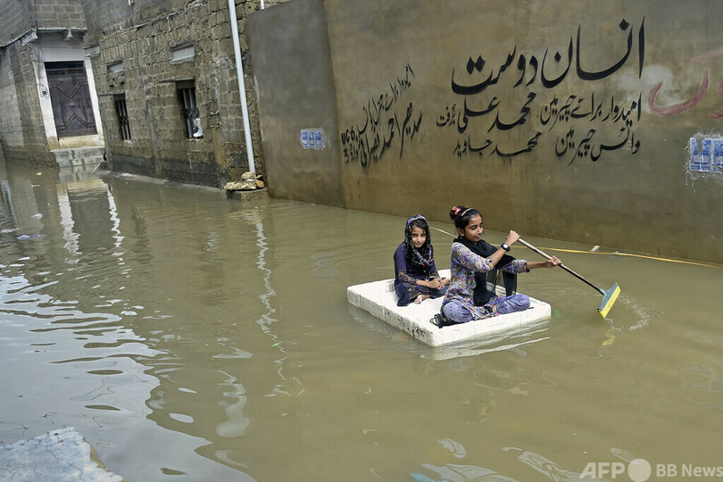 【今日の1枚】モップをオールに、冠水道路を行く パキスタン