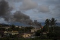 フィリピン南部ミンダナオ島のマラウィで、イスラム武装勢力の戦闘員に対する同国軍による空爆で立ち上る煙（2017年6月8日撮影）。(c)AFP/NOEL CELIS