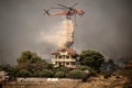山火事に見舞われたギリシャ・アルカネスで消火活動を行うヘリコプター（2023年8月23日撮影）。(c)Angelos Tzortzinis / AFP