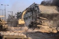 パレスチナ自治区ガザ地区で建物を破壊するイスラエル軍の重機。同軍提供（2023年11月11日撮影）。(c)AFP PHOTO / ISRAELI ARMY  