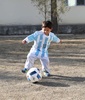 サッカー・アルゼンチン代表のリオネル・メッシ選手からプレゼントされたユニホームを着てボール遊びをするムルタザ・アフマディ君。ユニセフ・アフガニスタン支部提供（2016年2月25日提供）。(c)AFP/UNICEF Afghanistan/Mahdy Mehraeen
