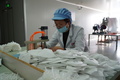 子供用マスクを生産する朝美日化の従業員（2020年3月20日撮影）。(c)Xinhua News