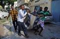 攻撃の犠牲者を運ぶ人々。(c)AFP/Mohamed Abdiwahab