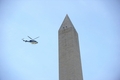 ワシントンD.C.のワシントン記念塔を上空から点検するヘリ（2011年8月23日撮影）。(c)AFP/Mandel NGAN