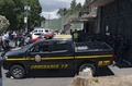 グアテマラの首都グアテマラ市近郊で、火災が起きた子どもの保護施設前で警戒に当たる警察官ら（2017年3月8日撮影）。(c)AFP/JOHAN ORDONEZ