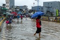 冠水した道を歩く人々。インドネシアの首都ジャカルタで（2020年2月25日撮影）。(c)BAY ISMOYO / AFP