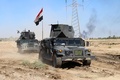 イスラム過激派組織「イスラム国」が支配していた地域を政府側が奪還した後、イラク・ヒートに近いアルマムラ村を移動するイラクの対テロ部隊の装甲車（2016年4月2日撮影）。(c)AFP/MOADH AL-DULAIMI
