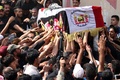 イラク南部バスラで営まれたイスラム教シーア派系民兵組織「人民動員隊」のベテラン狙撃手アブ・タフシン・サルヒ氏の葬儀で運ばれるサルヒ氏のひつぎ（2017年9月30日撮影）。(c)AFP/HAIDAR MOHAMMED ALIALI