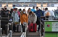 ウクライナ・キエフ郊外にあるボリスピリ国際空港のチェックインカウンターに並ぶ人（2022年2月13日撮影）。(c)Sergei Supinsky / AFP