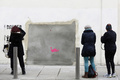 英国のグラフィティ（落書き）アーティスト、バンクシー（Banksy）氏がロンドン（London）市内の壁に描いた絵が、米国で競売にかけられることが分かったが、怒った住民たちの抗議によって競売への出品は中止されたと、地元自治体が24日、明らかにした。

写真は、バンクシー（Banksy）氏の壁画が持ち去られた後の壁を見つめる人たち（2013年2月23日撮影）。(c)AFP/JUSTIN TALLIS