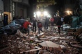 エジプトの首都カイロ近郊ギザで、爆弾が爆発した現場に立つ人々（2016年1月21日撮影）。(c)AFP/MOHAMED EL-SHAHED/MOY