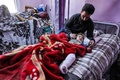 シリア北西部バブアルハワでけがをした子どもの面倒を見る男性（2023年2月6日撮影）。(c)OMAR HAJ KADOUR / AFP