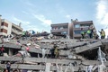 トルコのイズミルで、地震により倒壊した建物で行方不明者の捜索を行う人々（2020年10月30日撮影）。(c)MERT CAKIR / AFP