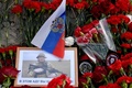 ロシア・サンクトペテルブルクの「ワグネル・センター」前で、死亡が確認されたワグネル創設者エフゲニー・プリゴジン氏の写真と手向けられた花（2023年8月25日撮影）。(c)Olga MALTSEVA / AFP