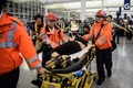香港空港で、デモ隊から中国のスパイと疑われ負傷した男性を搬送する救急隊員（2019年8月14日撮影）。(c)Anthony WALLACE / AFP