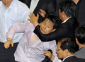 韓国国会で22日、与党ハンナラ党（Grand National Party、GNP）がメディア規制緩和法案を強行採決しようとしたため、与野党議員が国会で乱闘する騒ぎとなった。法案は可決されたが、十数人の負傷者が出た。写真は、与党議員らに引きずられる野党議員（中央、2009年7月22日撮影）。(c)AFP/JUNG YEON-JE