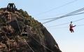 ブラジル・リオデジャネイロ（Rio de Janeiro）で、パン・デ・アスーカル山（Pao de Acucar）にあるロープエーのワイヤロープを滑車で滑り降りるサンタクロース姿の男性（2014年12月18日撮影）。(c)AFP/YASUYOSHI CHIBA