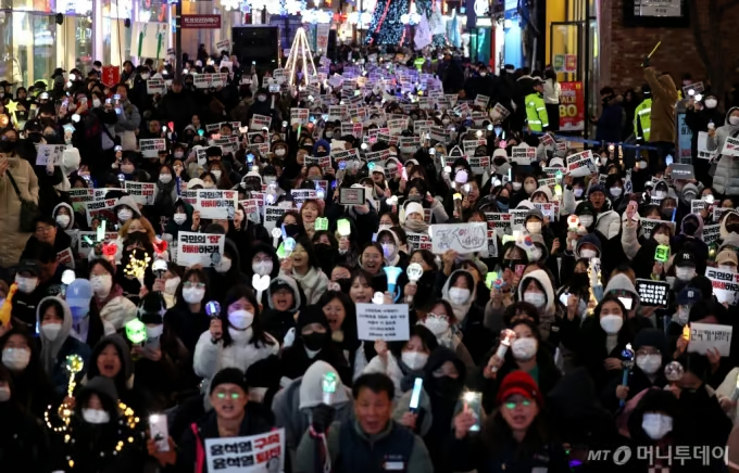 9日午後、大邱市中区で開かれた集会で応援棒を振る市民ら(c)NEWSIS
