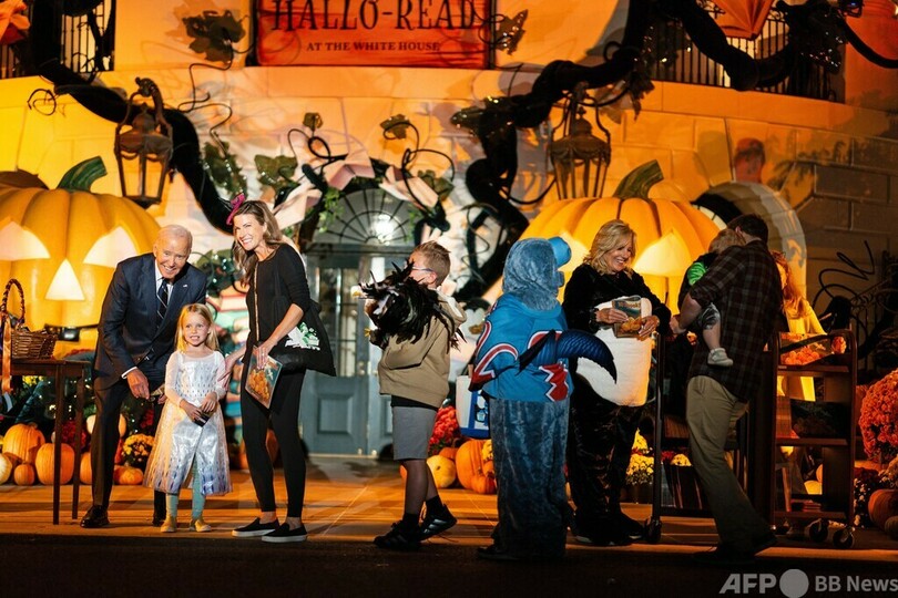 米首都ワシントンのホワイトハウスで行われたハロウィーンのイベントで、子どもにお菓子を渡したり、記念撮影に応じたりするジョー・バイデン大統領と着ぐるみ姿の妻のジル氏（2024年12月30日撮影）。(c)Tierney CROSS / AFP