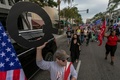 米カリフォルニア州ビバリーヒルズで、大統領選投票日前最後の週末に開かれたドナルド・トランプ大統領の選挙集会で陰謀論「Qアノン」の標識を掲げる男性（2020年10月31日撮影）。(c)DAVID MCNEW / AFP