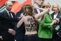 ドイツを訪問中のウラジーミル・プーチン（Vladimir Putin）露大統領は8日、同国北部ハノーバー（Hanover）の国際産業技術見本市の会場で、トップレスの女性から「くたばれ、独裁者」と罵声を浴びせられた。

写真は、プーチン大統領（左）に詰め寄るトップレスの女性。右の緑の服の人物はドイツのメルケル首相（2013年4月8日撮影）。(c)AFP/Jochen Lübke