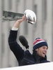 ボストン市内で行われた優勝パレードでヴィンス・ロンバルディ・トロフィーを掲げるニューイングランド・ペイトリオッツのQBトム・ブレイディ（2015年2月4日撮影）。(c)AFP/Getty Images/Billie Weiss