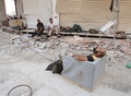 シリア政府軍が包囲してきたシリア・ダラヤの通りで休憩する政府軍の兵士ら（2016年8月26日撮影）。(c)AFP/Youssef KARWASHAN