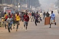 中央アフリカの首都バンギ（Bangui）で、店を略奪している最中に発砲音が聞こえ、逃げる人々（2014年1月11日撮影）。(c)AFP/ERIC FEFERBERG