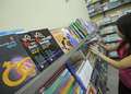 ミャンマー・ヤンゴン（Yangon）で、性教育雑誌「Hyno」を販売する書店で、本棚を見る客の女性（2013年1月5日撮影）。(c)AFP/Soe Than WIN