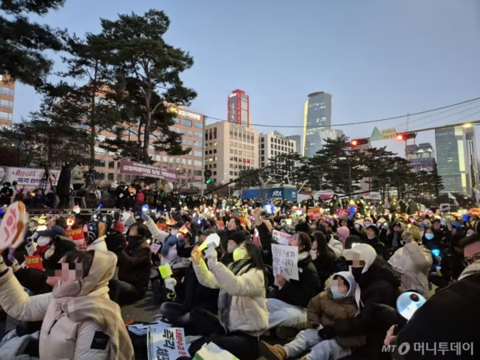 8日、ユン・ソンニョル(尹錫悦)大統領の弾劾を求める集会で、アイドルの応援グッズを手にスローガンを叫ぶ市民ら(c)MONEYTODAY