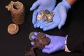 ユダヤ砂漠にあるムラバアト洞窟の発掘現場で見つかった15枚の銀貨。出土した筒（左上）の中に入っていた（2022年12月13日撮影）。(c)MENAHEM KAHANA / AFP