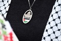 イスラエル建国に際しパレスチナ人76万人が故郷を追われた「ナクバ（大惨事）」の日に合わせ、5月にドイツ・ベルリンで行われた親パレスチナデモの参加者がしていたペンダント（2024年5月18日撮影）。(c) RALF HIRSCHBERGER / AFP
