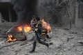 シリア政府軍とロシア軍によるものとされる爆撃があったシリア首都ダマスカス近郊の東グータで、負傷した子どもを運ぶ救急隊員（2018年1月6日撮影）。(c)AFP PHOTO / ABDULMONAM EASSA