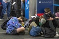 米カリフォルニア州ロサンゼルスの空港でチェックインのため並ぶ旅行客（2021年12月23日撮影）。(c)DAVID MCNEW / AFP